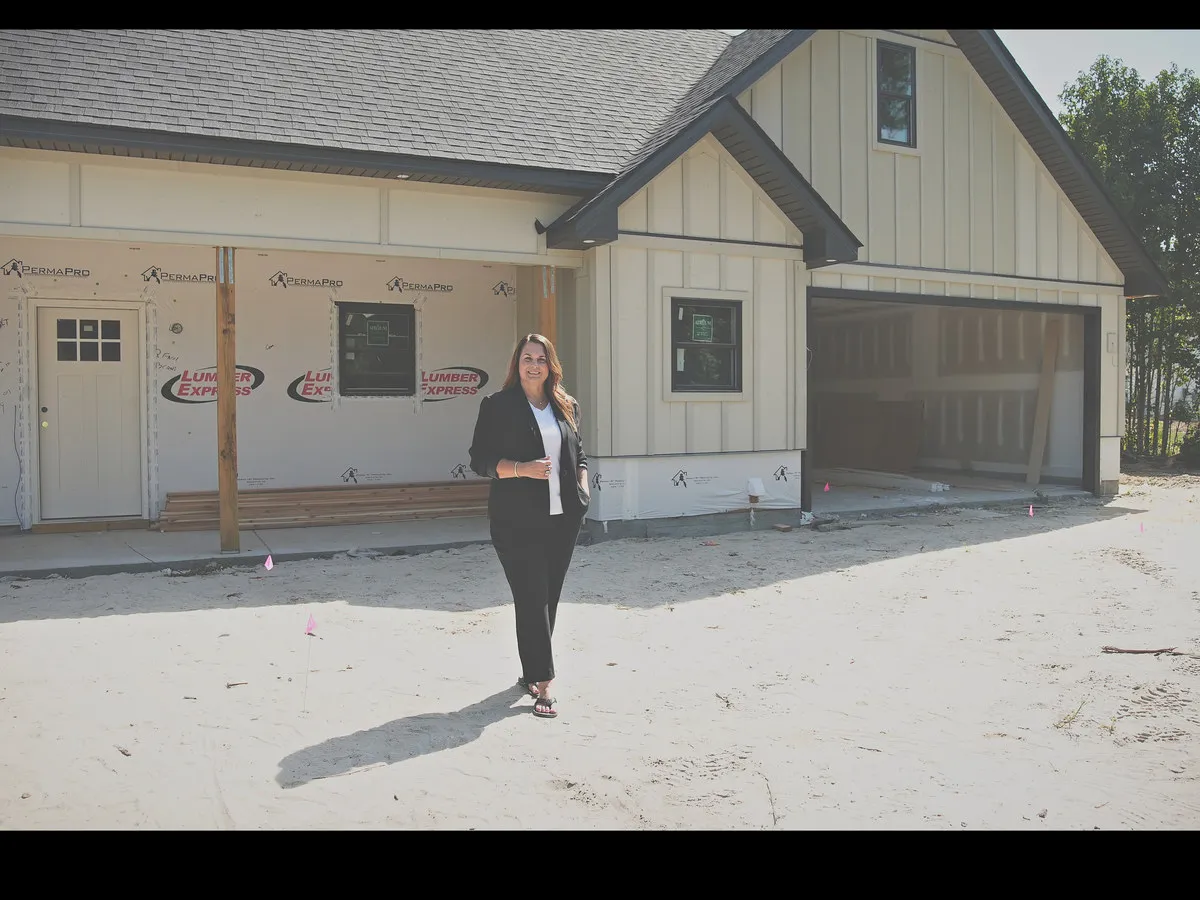 Nyla Hucks standing in front of a home under construction at Bucksville Crossing